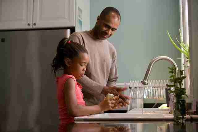 dad helping daughter cook