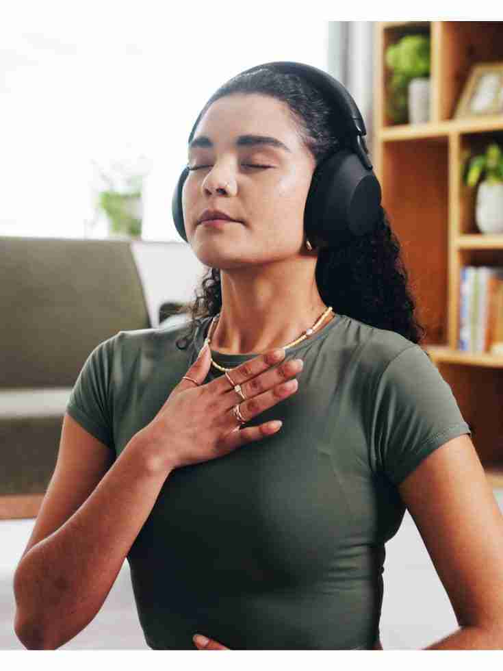 woman doing breathing exercise while wearing headphones