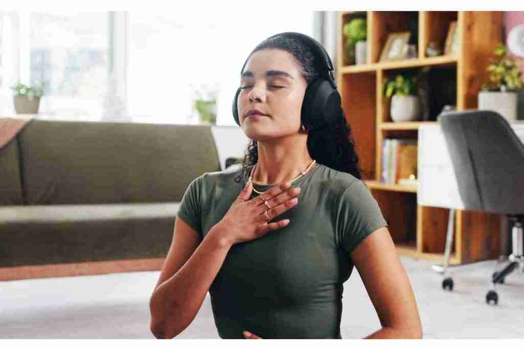 woman doing breathing exercise while wearing headphones