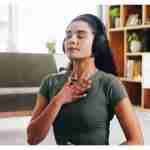 woman doing breathing exercise while wearing headphones